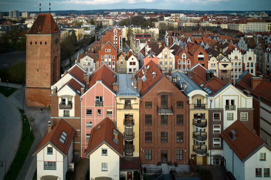 Colorful residential townhouses aerial view with red tile roofs historic market square medieval tower defensive architecture Elblag Old Town - Powered by Adobe