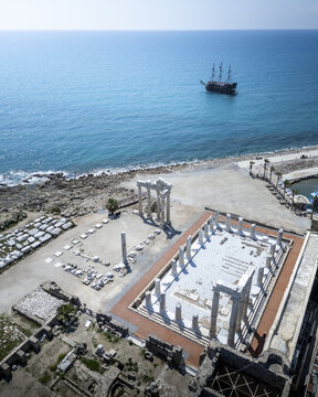 The Apollon Temple with a sea view and a distant ship, Side, Antalya, Turkey.