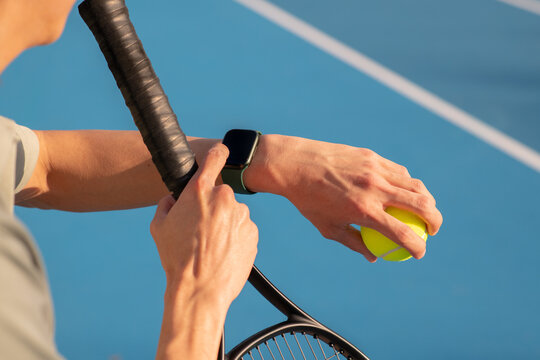asian man checking his fitness smartwatch at tennis