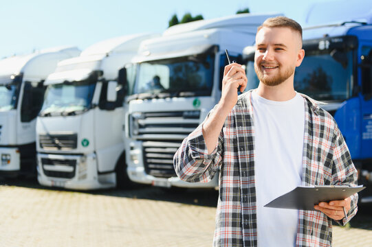 Truck driver communicating using walkie talkie holding clipboard