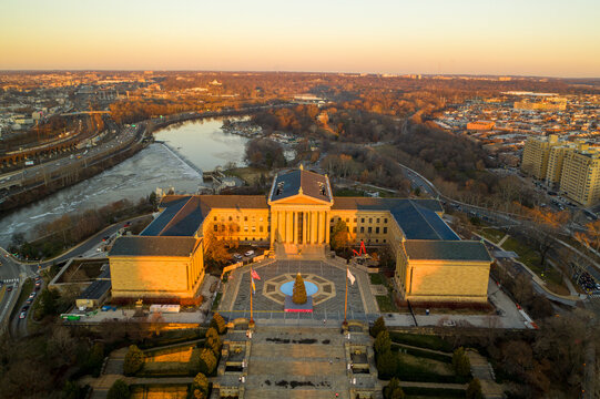 Aerial view of the Philadelphia Museum of Art bathed in the warm glow of the setting sun, the Schuylkill River winding behind it, Philadelphia, Pennsylvania, United States.
