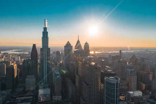 Aerial view of the sun's golden rays kissing the Comcast Technology Center and the iconic skyline's peaks, Philadelphia, Pennsylvania, United States.
