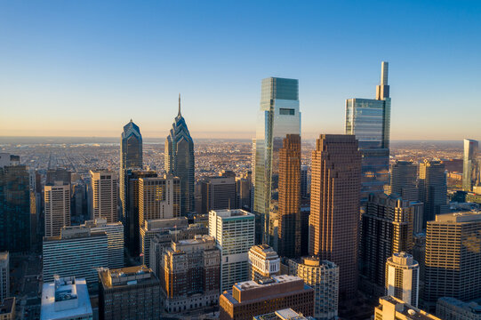 Aerial view of the cityscape, with the Comcast Technology Center and One Liberty Place piercing the horizon, bathed in the warm glow of the setting sun, Philadelphia, Pennsylvania, United States.