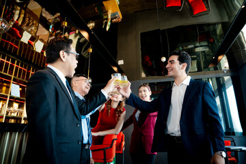 Cheers to success! Business professionals enjoying a celebration with drinks at a stylish bar. Teamwork and good times.
