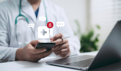Doctor using smartphone and laptop with telemedicine notification icons showing online consultation and digital healthcare communication for modern medical technology systems
