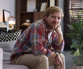 Fototapeta premium Portrait of man sitting on sofa at home