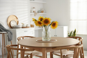 Beautiful sunflowers in vase on dining table at home