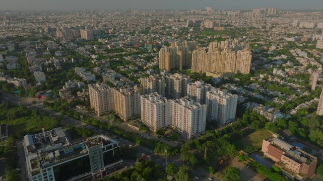 Aerial view of buildings interspersed with greenery, the scene showcases the urban landscape with a blend of residential complexes, Gurugram, Haryana, India.