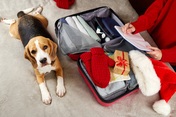 The girl is packing a suitcase for a trip to the Christmas holiday