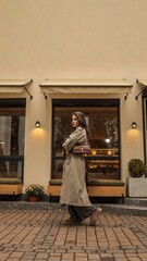 Stylish girl in a trench coat walking on a city street