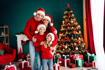Happy family celebrating Christmas around the beautifully decorated tree with warm sweaters and festive smiles at home