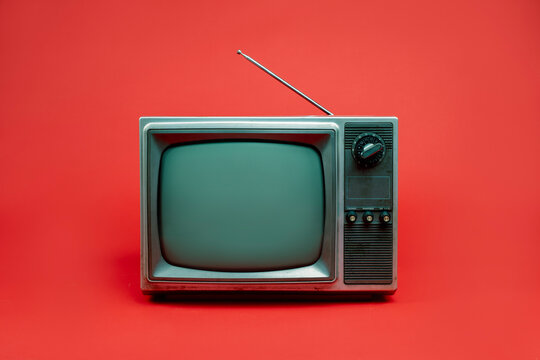 Front view, retro red old television with blank screen, vintage analog old fashioned TV isolated on red background.