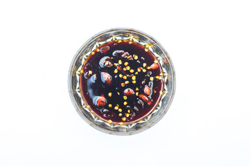 top view of hot sauce made from red chilies, olive oil, soy sauce, in a glass bowl on a white background,