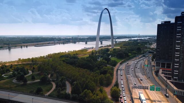 Footage over the green park approaching the iconic Gateway Arch over the Mississippi River. Scenery of St. Louis, Missouri, USA at daytime.