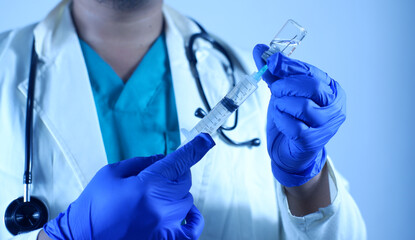 doctor's hand holds a syringe and a vaccine bottle at the hospital. Health and medical concepts. vaccination flu shot paramedics in hospital concept.selective focus hand doctor syringe injection.