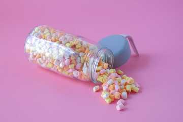 Colorful sweet candy in bottle on background.