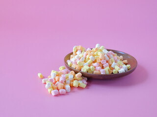 Colorful sweet candy in wood dish on background.