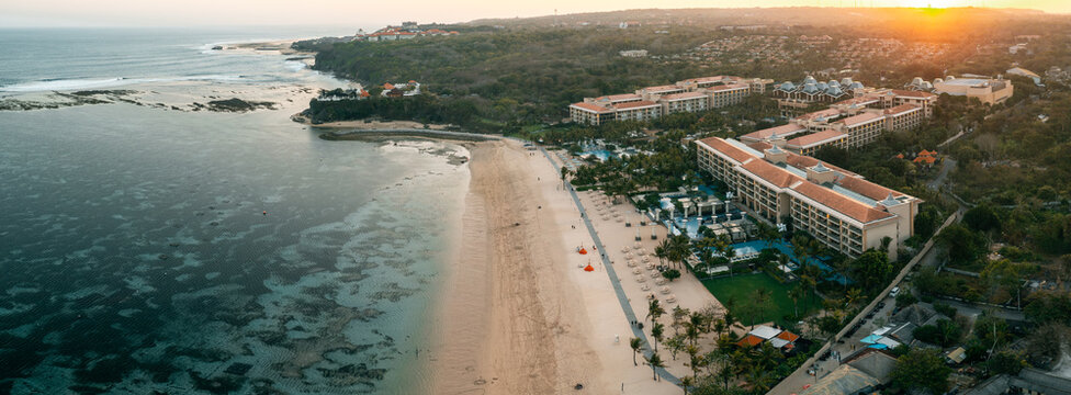 Nusa Dua beach Bali luxury resort area and famous tropical beach destination for wealthy travelers seeking peaceful vacation away from crowds, Bali Indonesia 4K Aerial view - Powered by Adobe