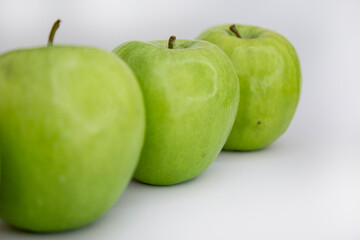Diagonal Row of Green Apples on White Background with Copy Space – Minimalist Fruit Flat Lay
