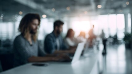 Modern office workers collaborate and focus on tasks using laptops in a bright naturally lit workspace