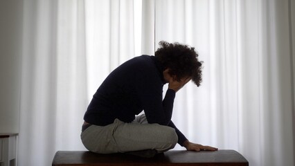 Desperate man in depression at home in bedroom despairs and cries for failure and panic attack and...