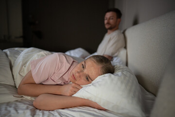 Sad disappointed woman turn away from husband in bed after conflict, intimacy issues. Unmet...