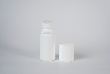 Clean white roll-on deodorant bottle with open cap, minimal body care product concept. 