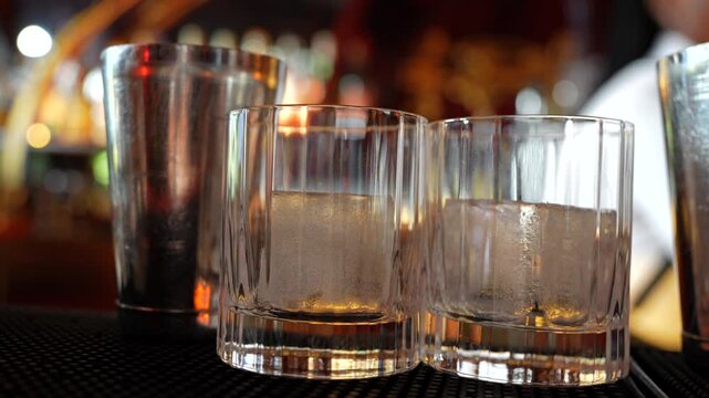 Bartender working behind bar with glasses and shakers
