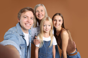 Man taking selfie with his mom and family on brown background