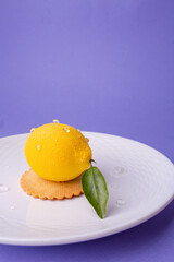 A hyper-realistic lemon-shaped dessert with water droplets and a single leaf, served on a textured white plate. Perfect for patisserie ads, summer menus, or premium dessert campaigns