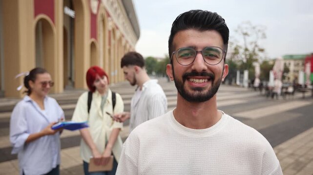 A man with glasses is smiling at the camera