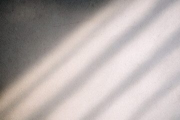 Diagonal shadows stretch across a textured wall, creating an interplay of light and shadow. The simplicity adds a calming effect.AI generated.