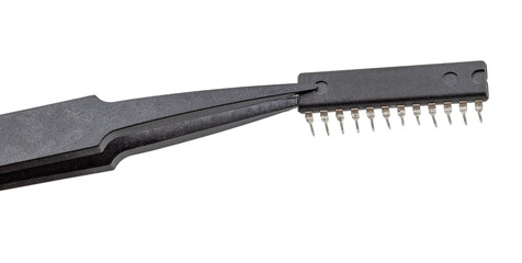 Tweezers hold a chip on a white