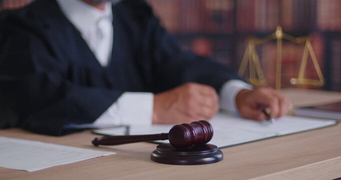 Gavel before judge as symbol of court verdict on case in courtroom and jurisprudence. Wooden hammer lying on block near legal documents, law and justice scales on desk, waiting decision during trial