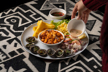 Peruvian ceviche served with grilled shells, fried cassava, fried octopus, and fresh sweet corn salad