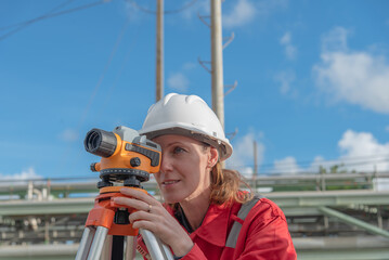 Woman engineer using theodolite outdoors