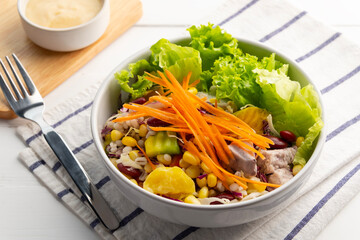 Mix cereal and Vegetable salad in white bowl.and creamy salad dressing.Healthy diet food.