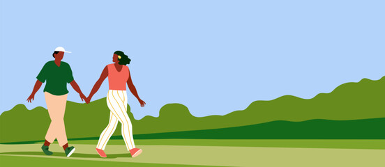 Two Women Walking Outdoors on a Summer Day. Two women walking hand in hand in a green landscape with blue sky and distant hills