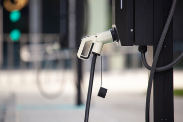 Electric vehicle charging station with a charging plug ready for use in a modern urban environment