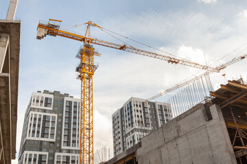Construction site with a tall crane overseeing the development of modern apartments under a bright...