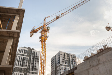 Construction site showing active crane and modern buildings during late afternoon in an urban...