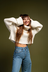 Young woman radiating warmth in cozy autumn fashion while posing with joy