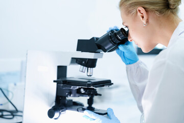 A pharmaceutical Quality Control QC team ensures GxP compliance. Two scientists review an electronic batch record on a tablet while a third performs a required analytical test.