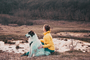 Woman and dog enjoying outdoors on a green field