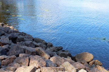There are large stones on the seashore.