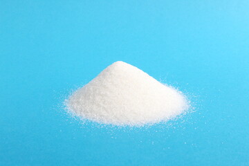 There is a pile of crumbly sugar on a blue background.