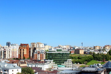 View of a city with houses and trees on a sunny hot summer day.	