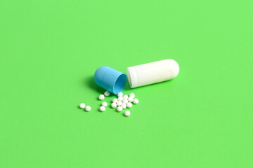 There is a medicine capsule on a green background.