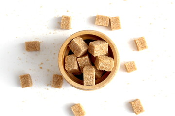 There are a lot of brown sugar cubes in the sugar bowl.	