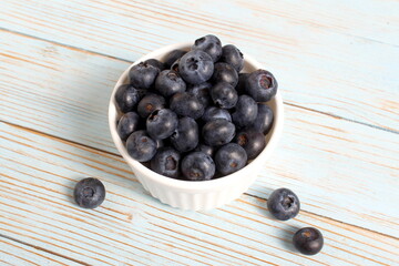 There is a bowl of ripe blueberries on the table.	